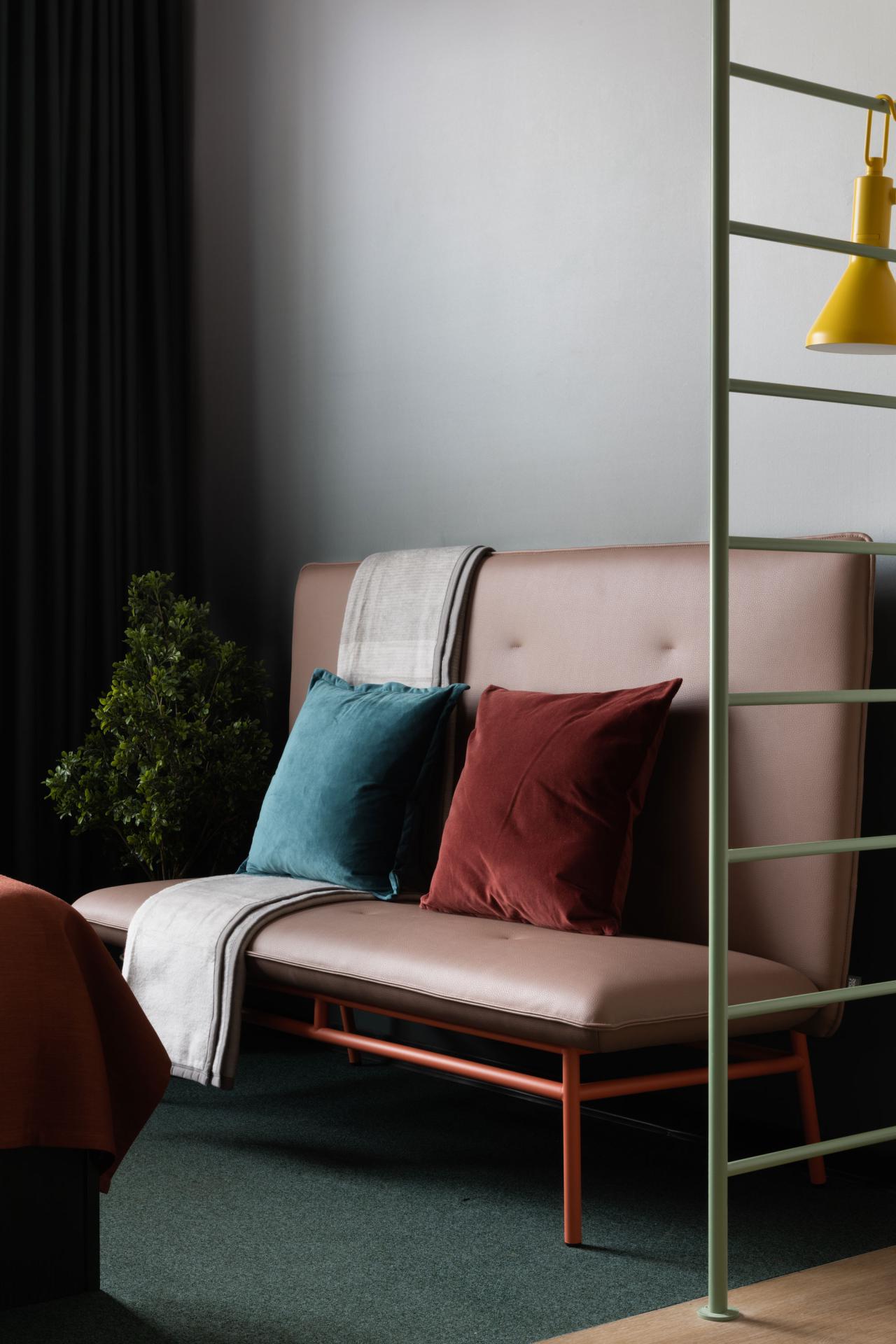 Pink sofa with colourful cushions in a room at Basecamp Dortmund Hotel