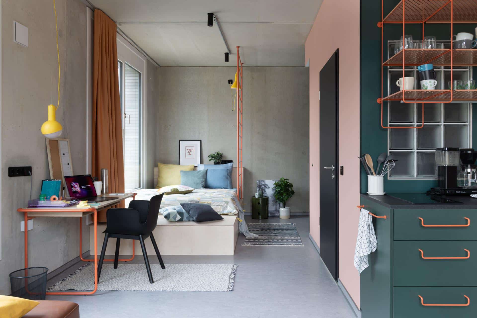 Bed and lounge area of a single L room with kitchenette at Basecamp Dortmund student housing