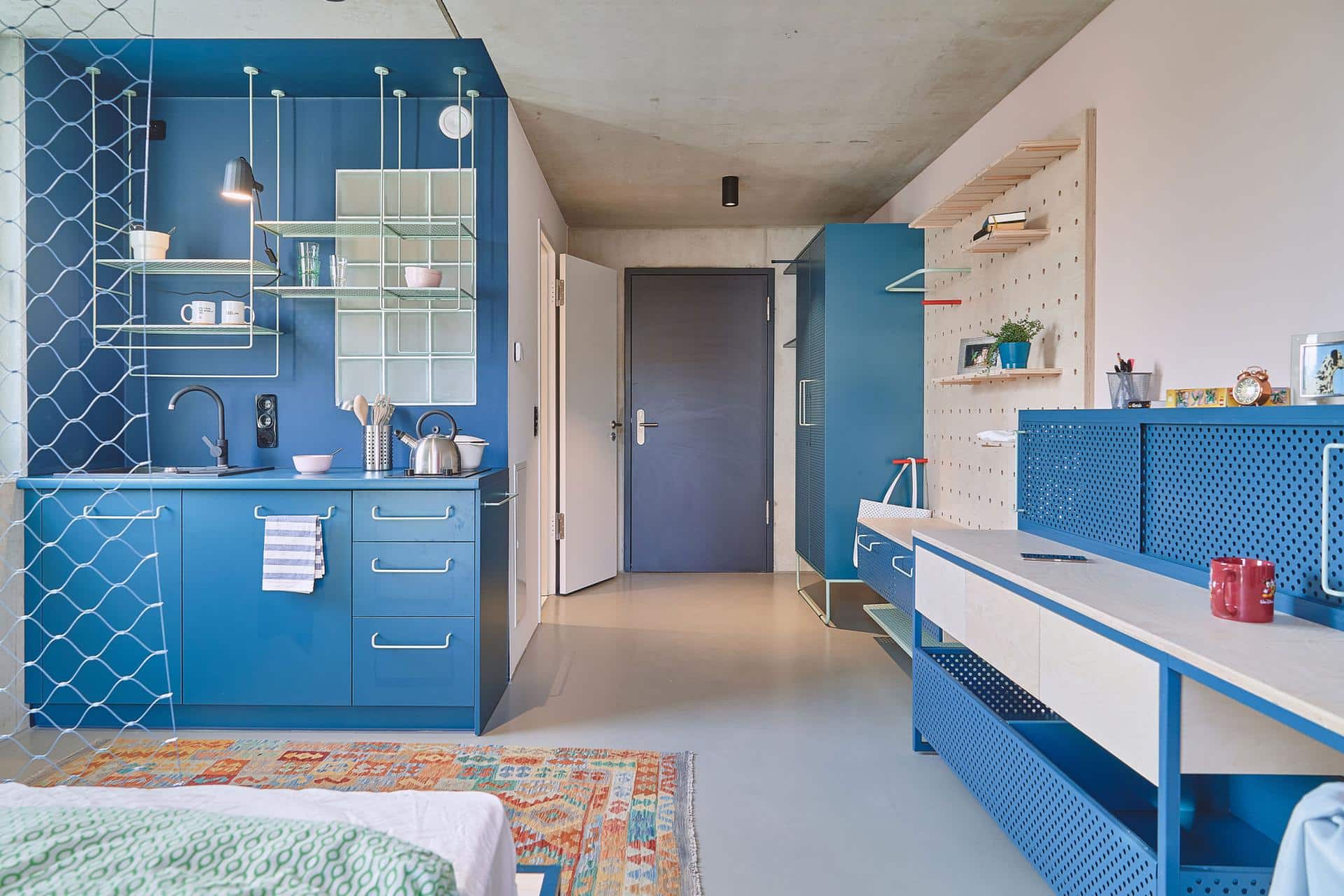 Kitchen and study area of a studio room with kitchenette at Basecamp Leipzig student dormitory