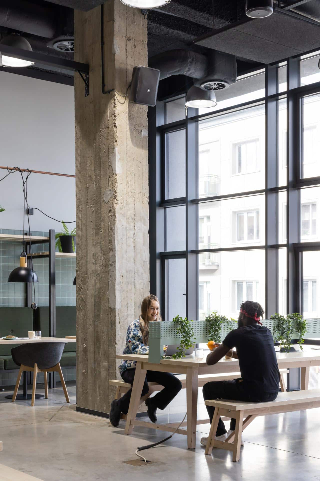 Two students studying in one of the spacious and bright study areas at  Basecamp Łódź Rewolucji student accommodation 