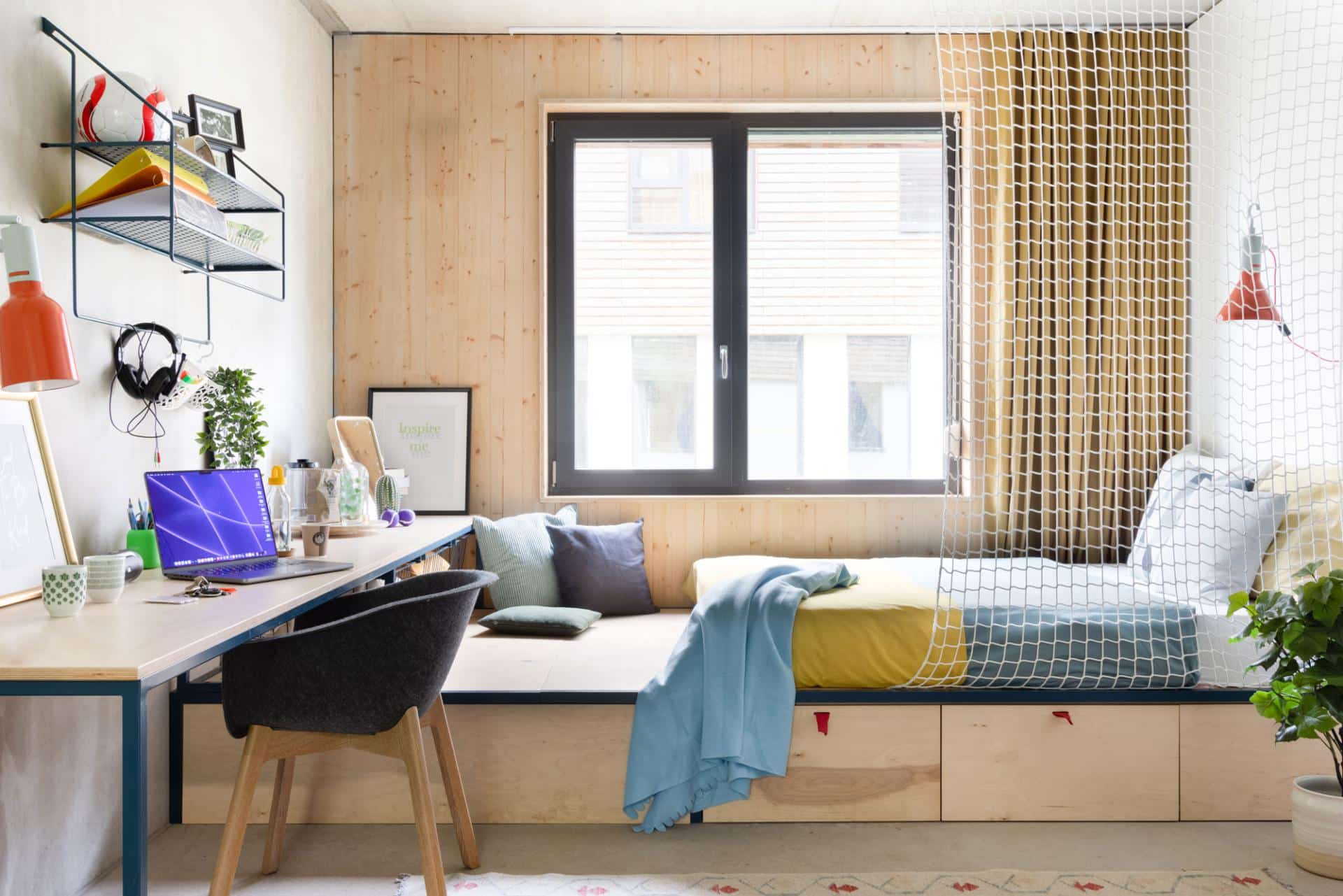 bedroom with large window and study desk in a studio room at Basecamp Potsdam student accommodation