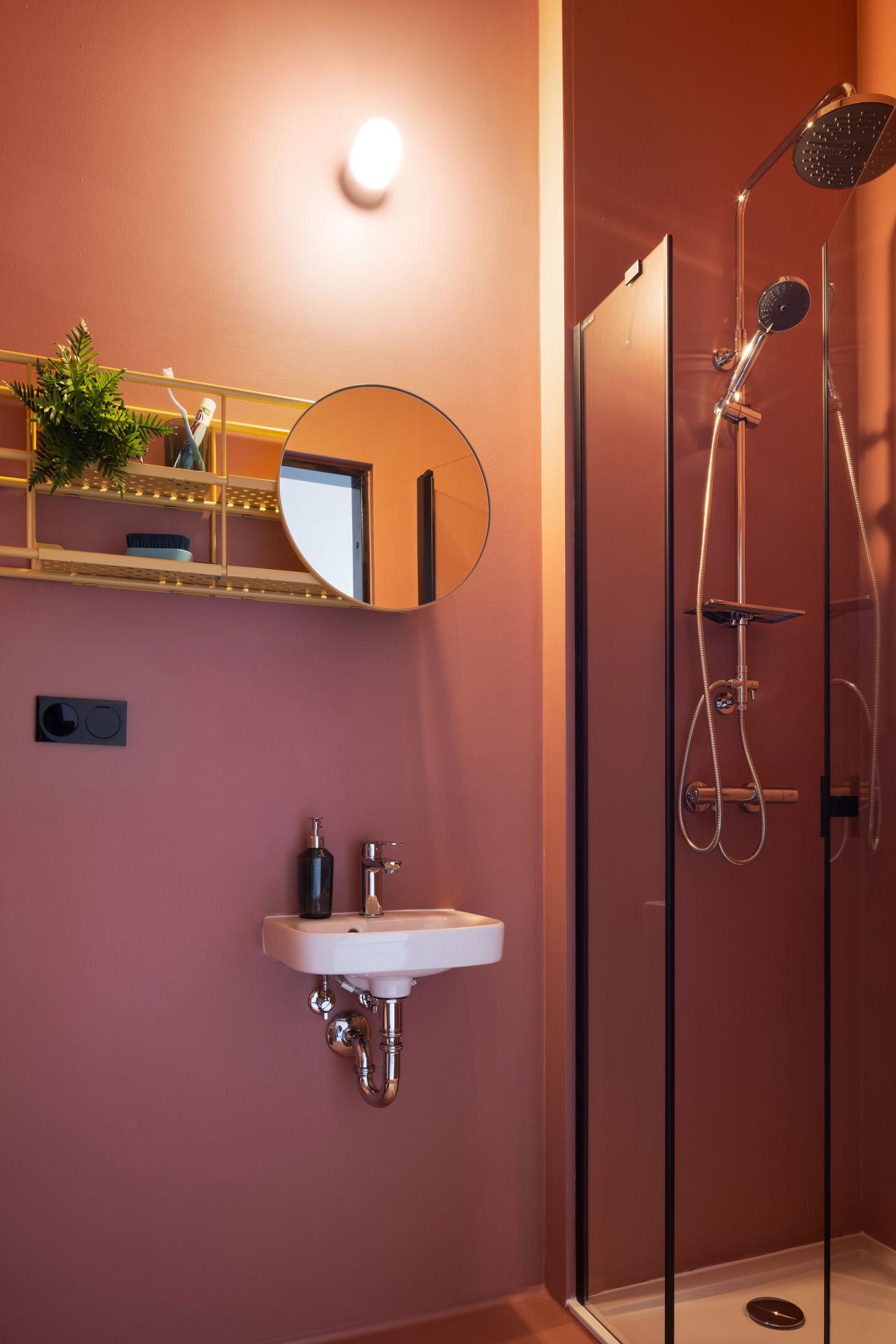 Sink, shower and mirror in the private bathroom of a student room at Basecamp Wroclaw dormitory