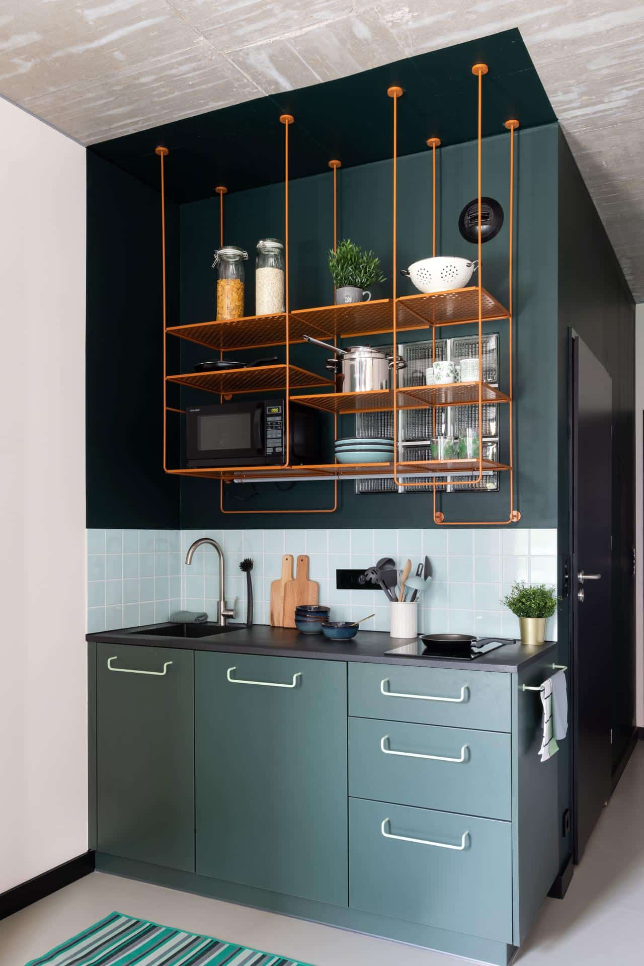 green kitchen with spacious shelves in a student room at Basecamp Wroclaw dorm