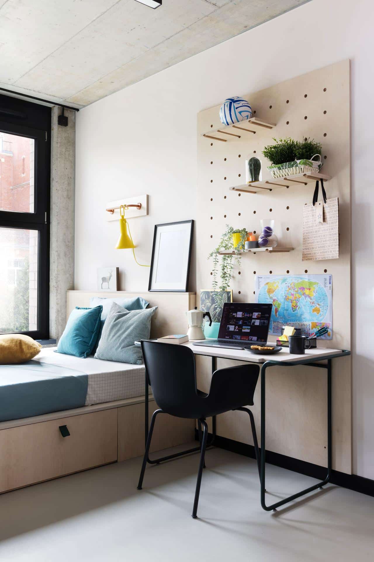 Bed and study area of a studioroom for students in Basecamp Wroclaw