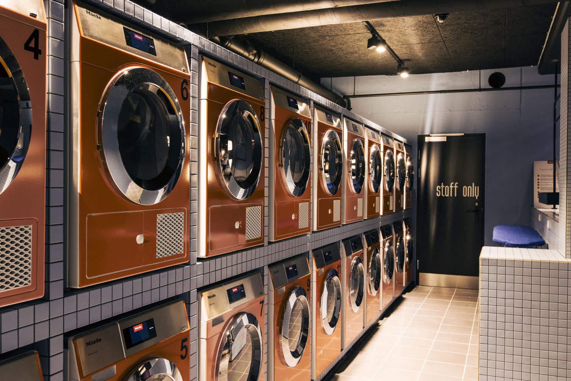 Laundry machines and dryers in the laundry area at Basecamp South Campus dorm