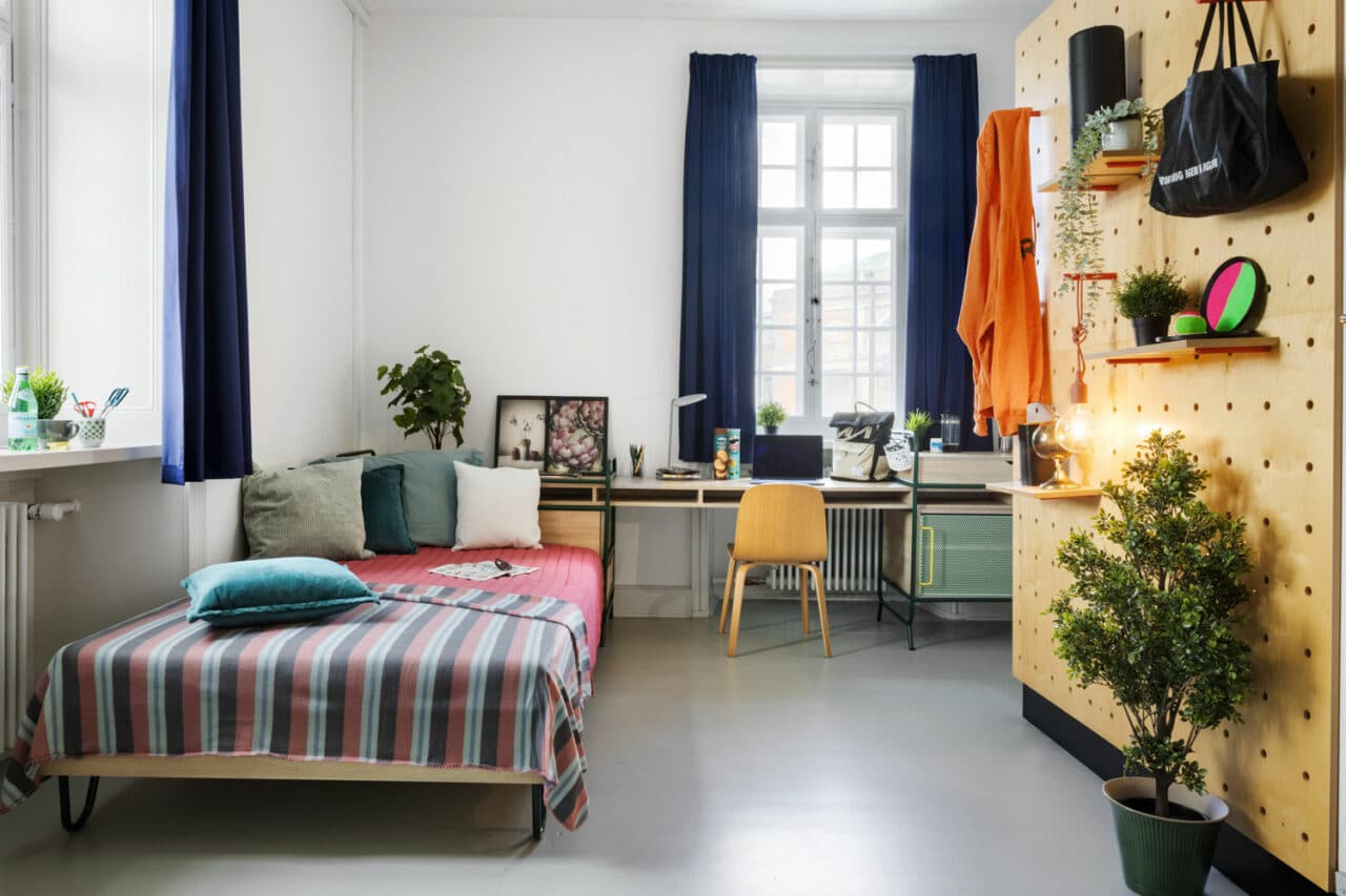 bed and study area of a singe L room at Basecamp Copenhagen student accommodation