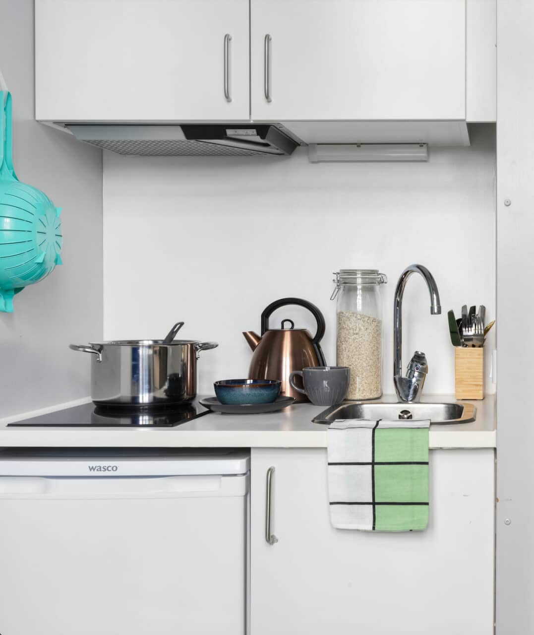 Single M room kitchenette with a hob, sink, fridge at Basecamp Copenhagen student housing