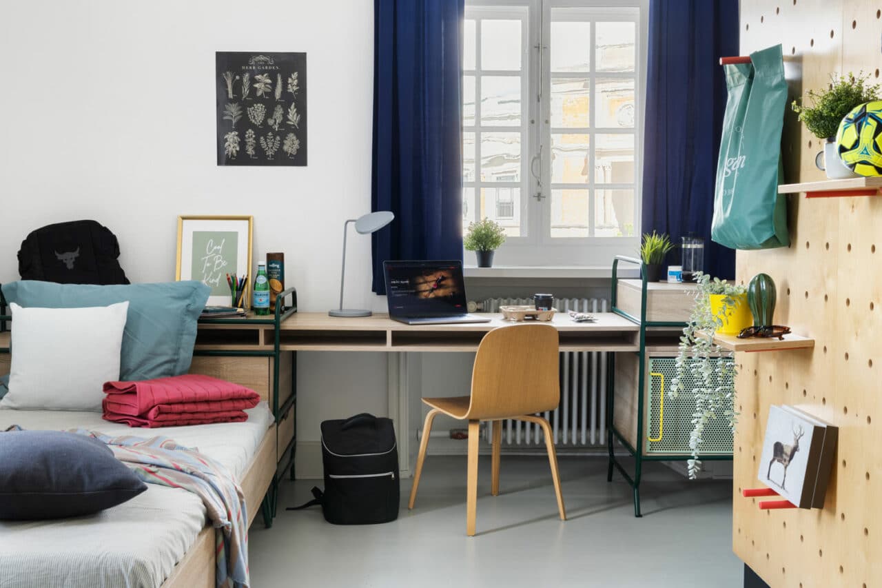 bed and study area of a Single M room at Basecamp Copenhagen student accommodation