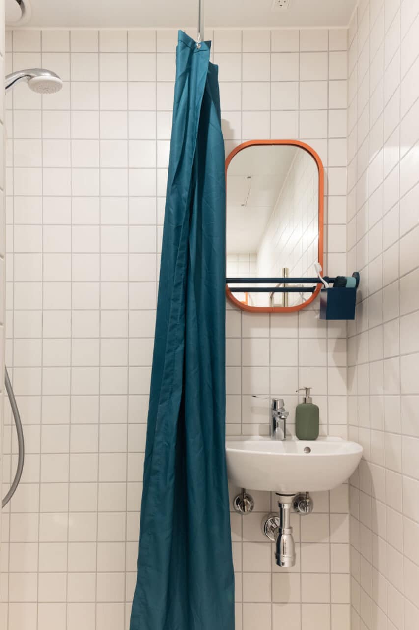 Shower and sink in the private bathroom of a single room in Basecamp Copenhagen