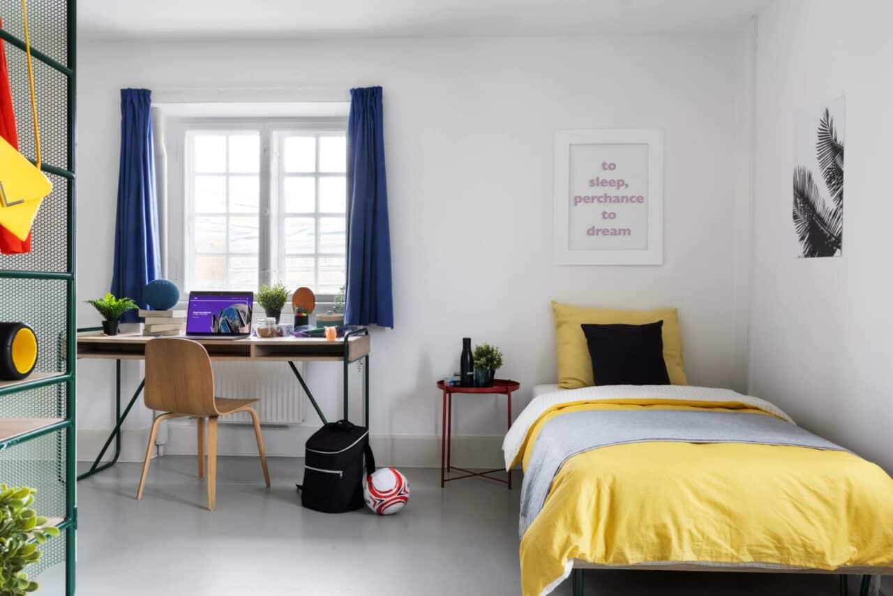 bed and study area of a student room at Basecamp Copenhagen student accommodation