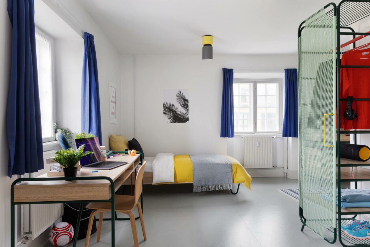 bed and study area of a L room at Basecamp Copenhagen student accommodation