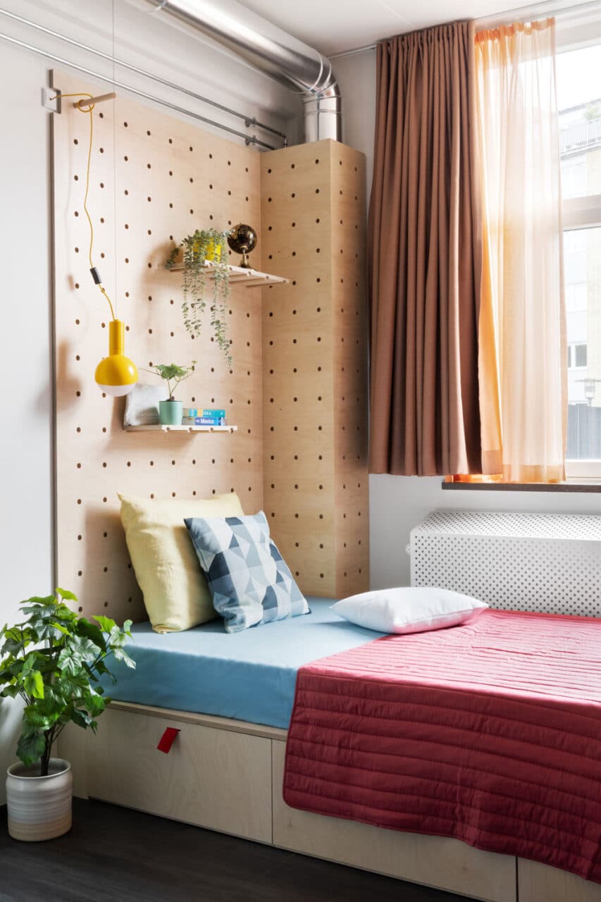 bed with shelves and a view of Copenhagen streets at Basecamp South Campus student housing