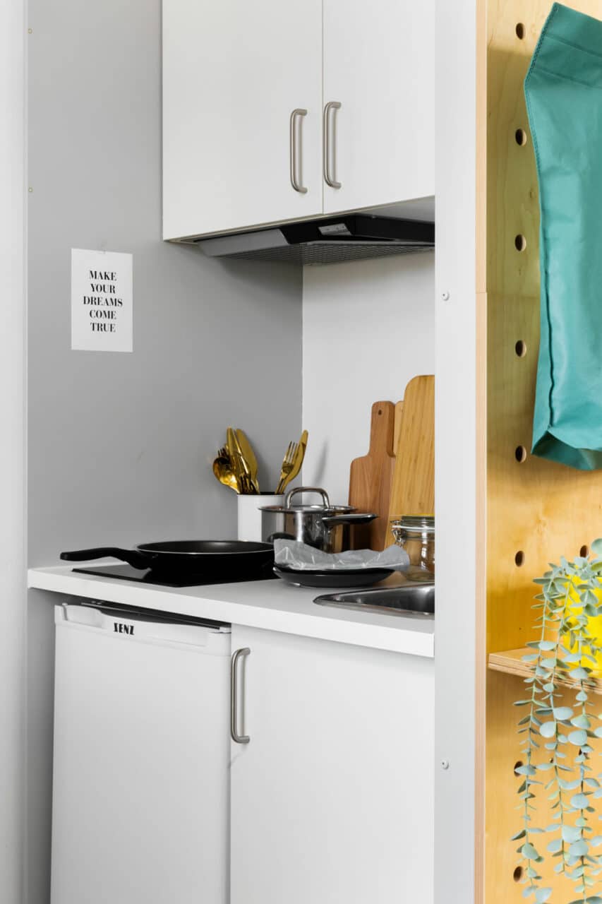 Studio XL room kitchenette with a hob, sink, fridge at Basecamp Copenhagen student housing