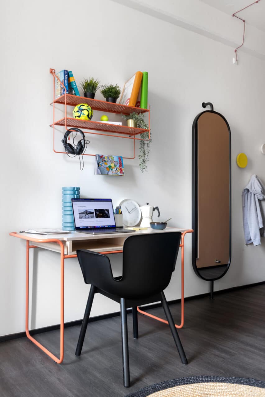 desk and shelves with books, plants and a football in a study area of a private studio room at Basecamp Copenhagen dorm