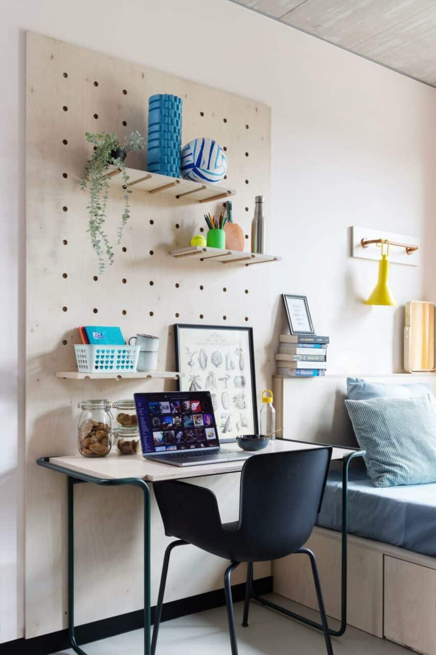 bed and study area of a Single studio room at Basecamp Wroclaw student accommodation