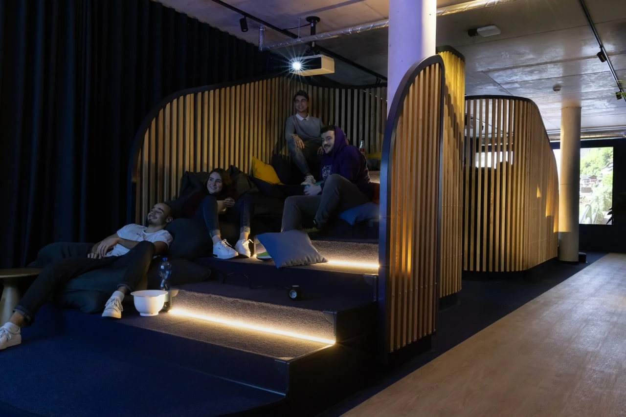 Students watching a movie in the Cinema room at Basecamp Dortmund student accommodation