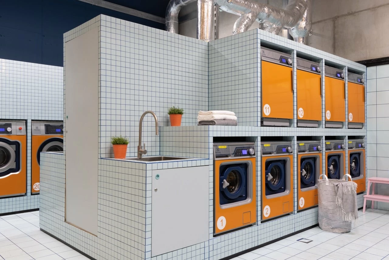 Orange laundry machines and dryers at Basecamp Katowice dorm