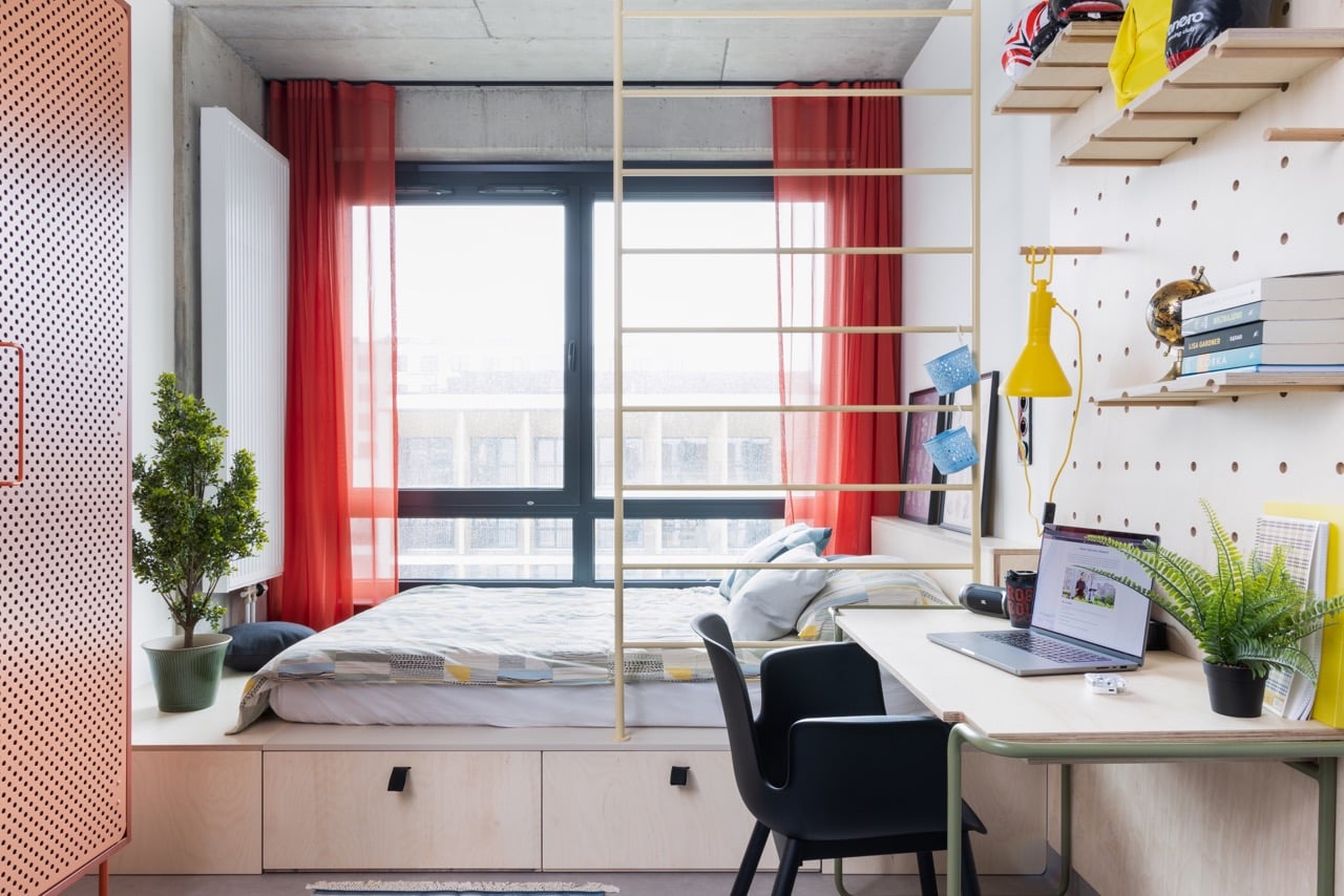 bed with storage and a wardrobe in one of the Studio rooms at Basecamp Katowice student housing