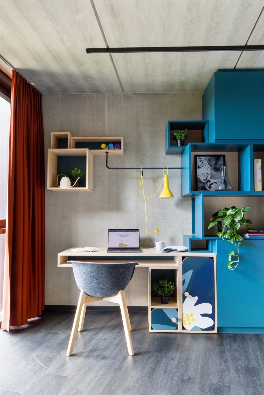 View of a large room for students at Basecamp Lyngby showing a study area with desk and chair