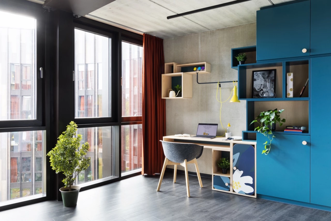 View of a large room for students at Basecamp Lyngby showing a study area with desk and chair