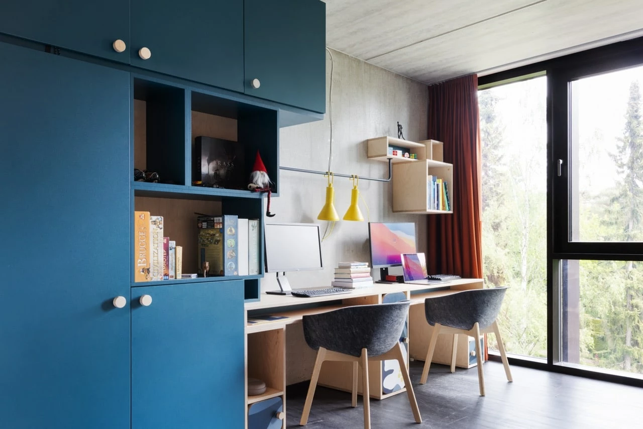 a study area with a desk and two chairs in a large student room in Basecamp Lynbgy student accommodation