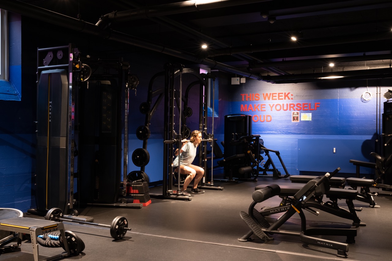 Free weights area with racks and gym machines in the large, state of the art gym at Basecamp Copenhagen Student housing