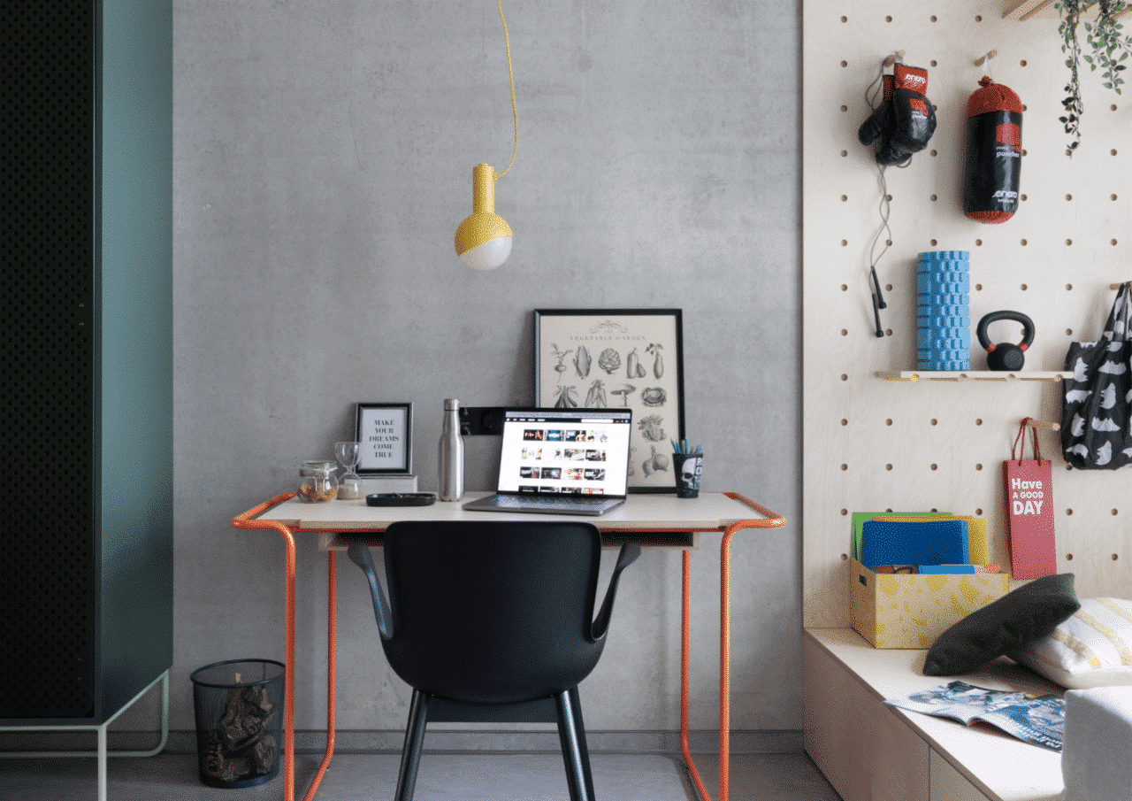 private study area of a studio room in Basecamp Dortmund with large desk, shelves and storage area