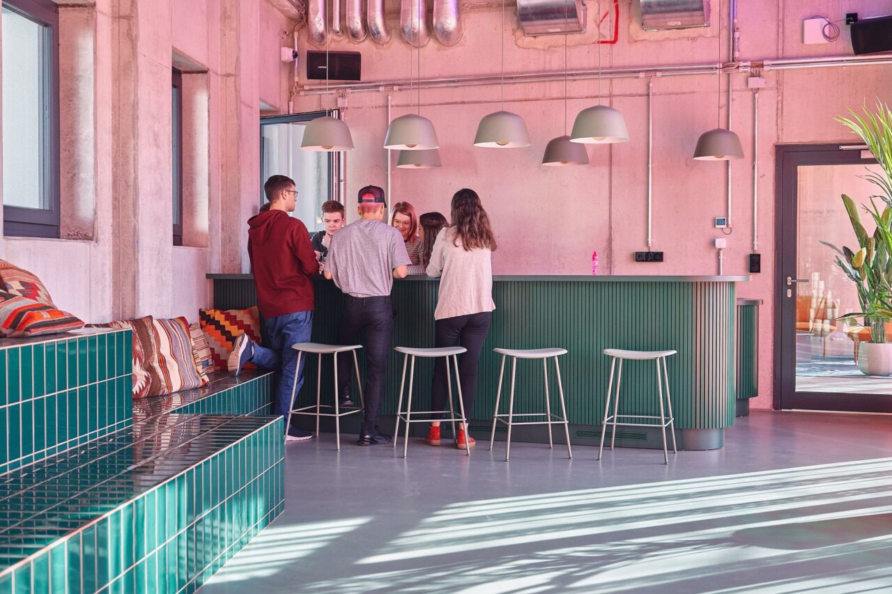 Students chat and eat in one of the Lounge Areas at Basecamp Leipzig student dormitory