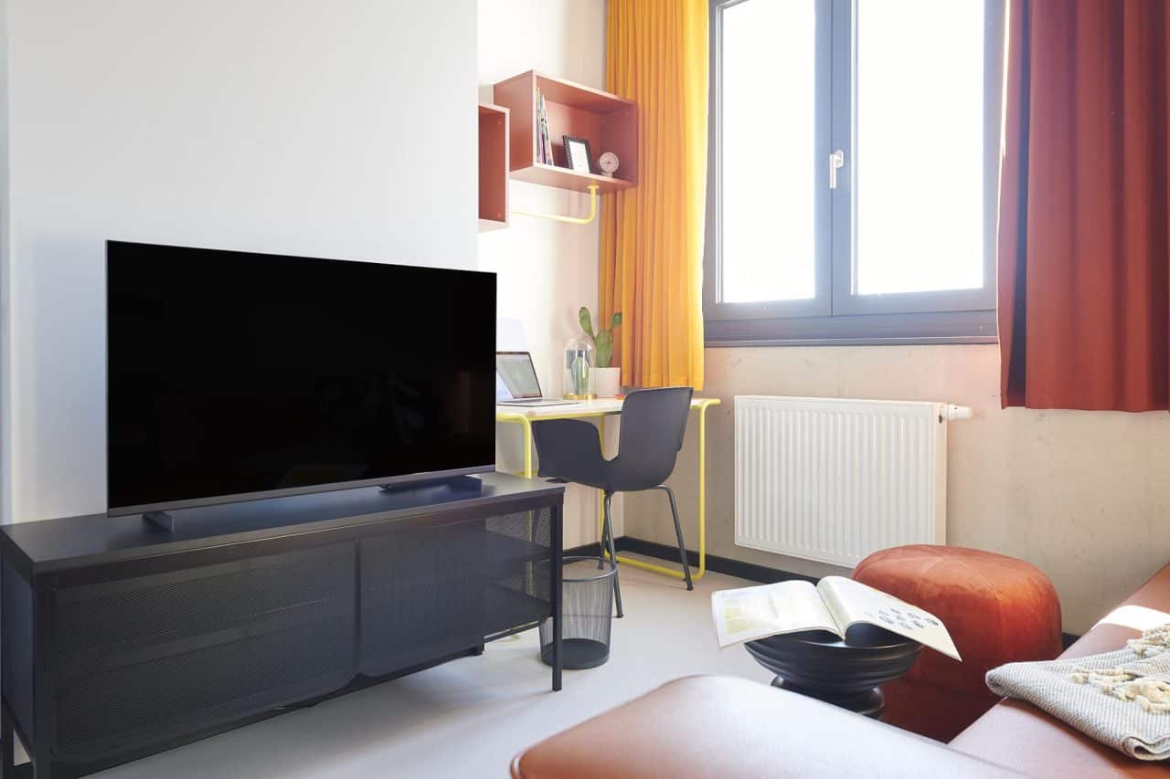 Tv and study desk in an apartment at Basecamp Gottingen student dorm