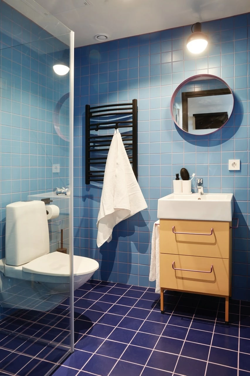 Private bathroom showing shower, toilet, sink, mirror and heated towel rail in one of the rooms at Basecamp Malmö student accommodation