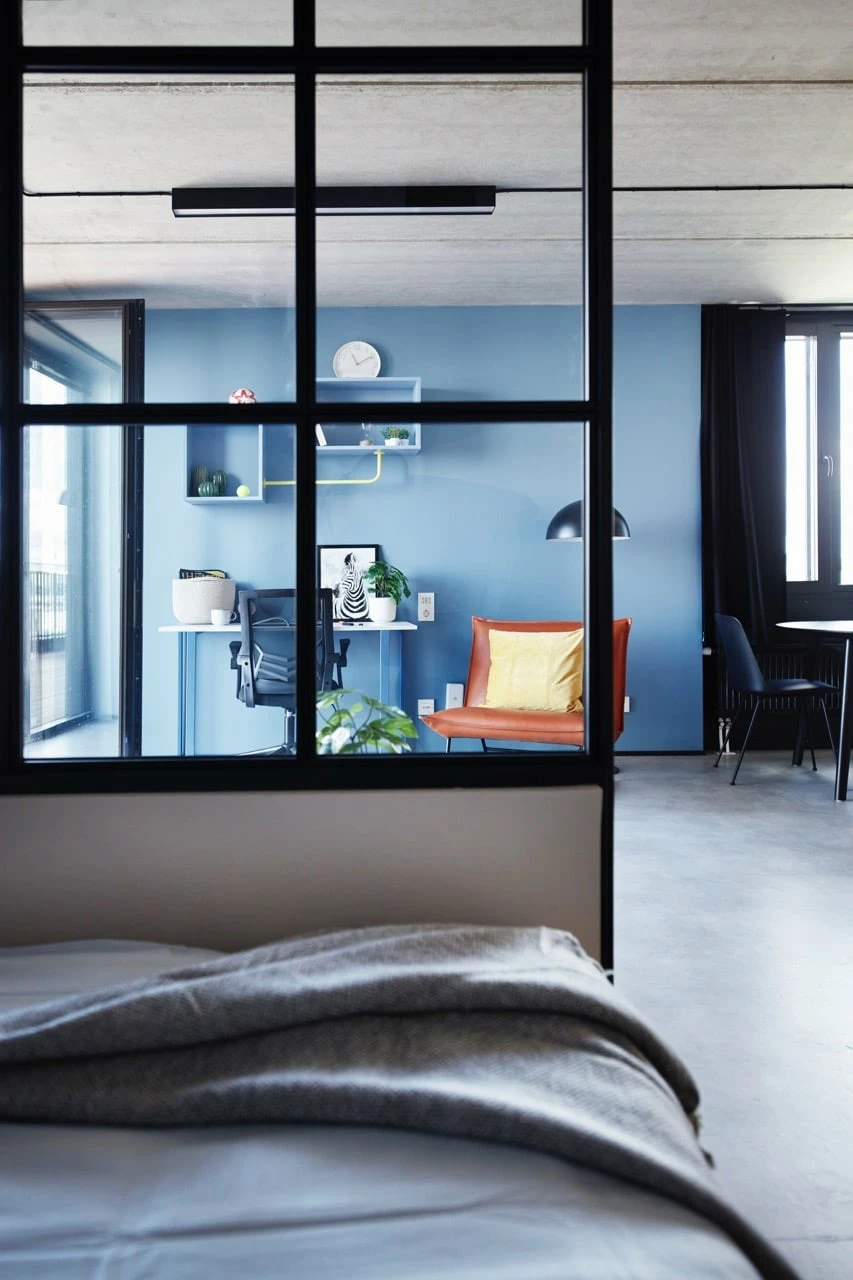 view from the large bed into the living and study space in a penthouse apartment at Basecamp Malmö student accommodation