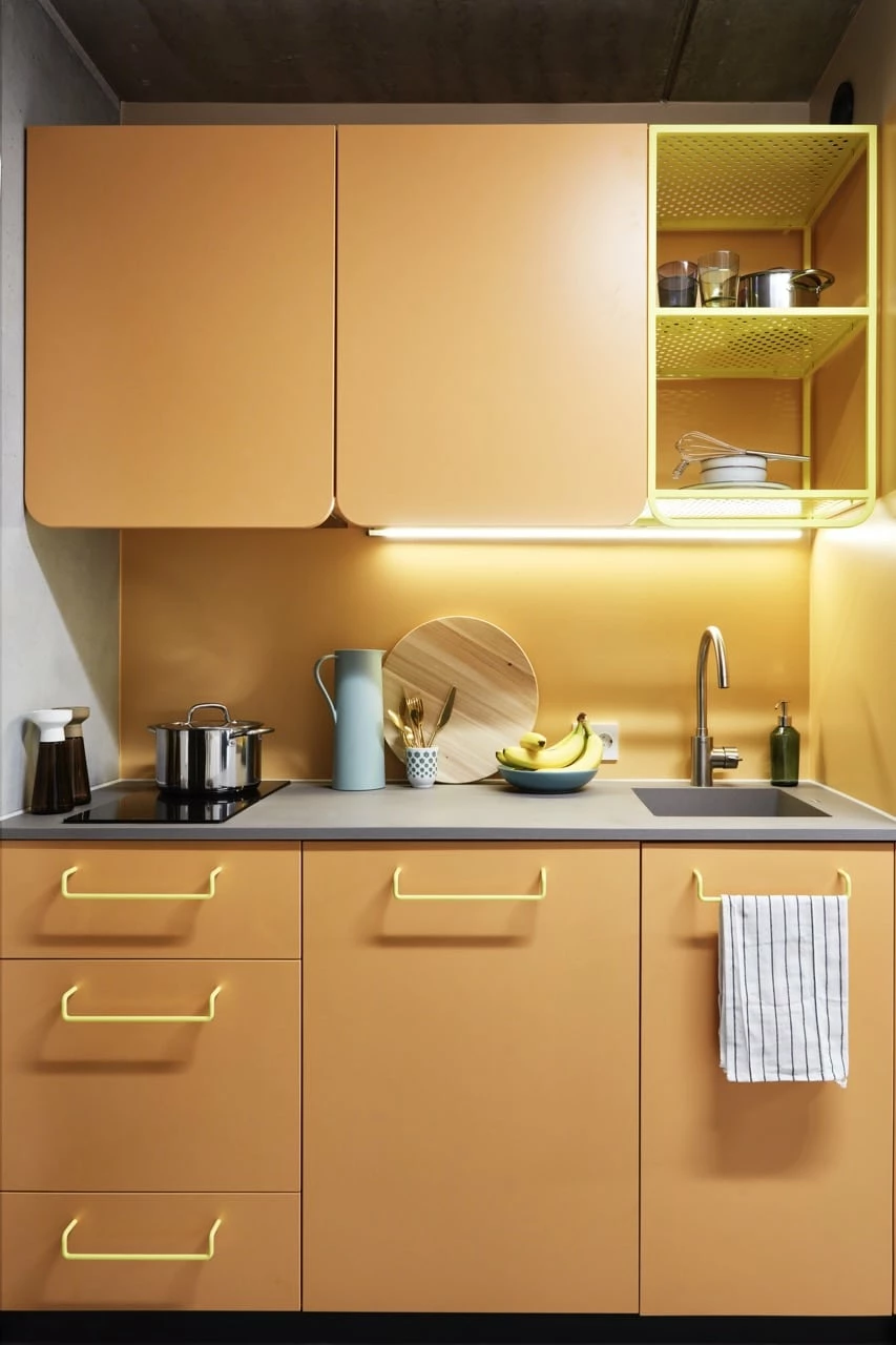 Studio room kitchenette with a hob, sink, fridge and storage space at Basecamp Malmö student accommodation