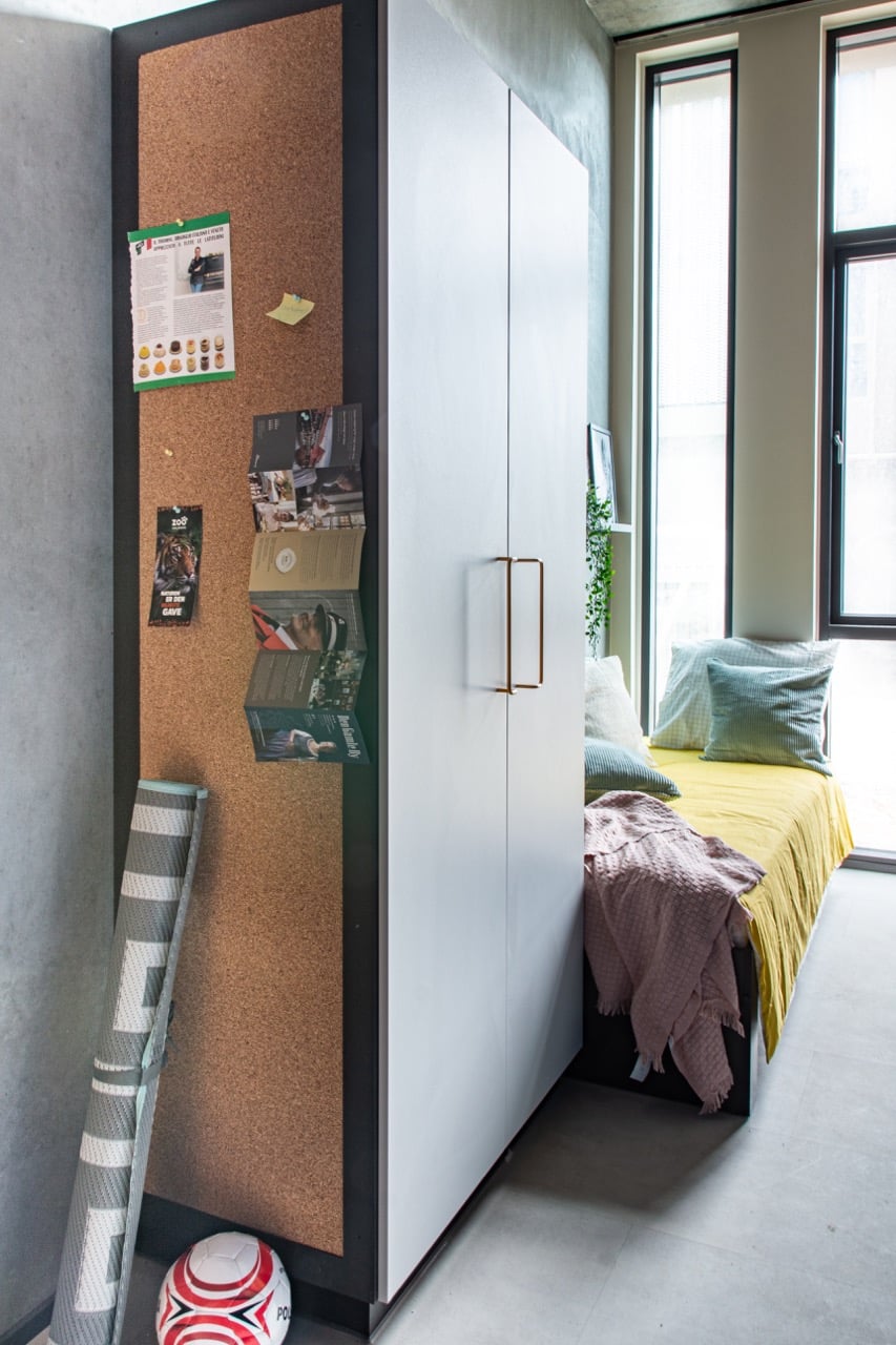 Bed and wardrobe in a student single with kitchenette room at Basecamp Aarhus