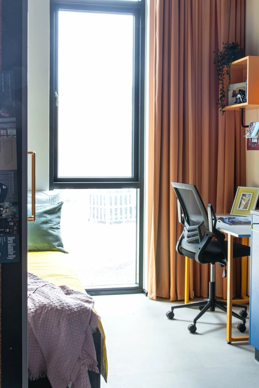 Study area with desk, storage and chair in a single with kitchenette student room at Basecamp Aarhus