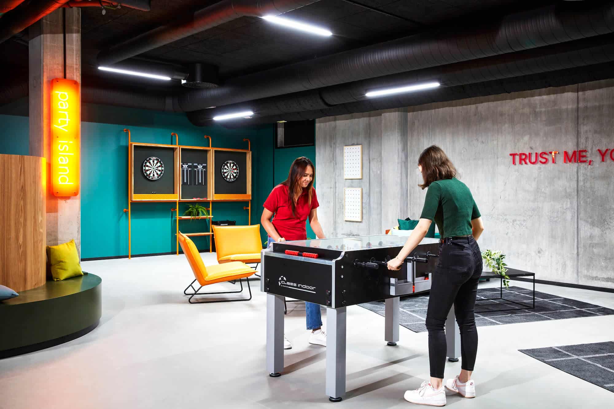 Two student residents playing foosball in the communal game zone at Basecamp Malmö student housing