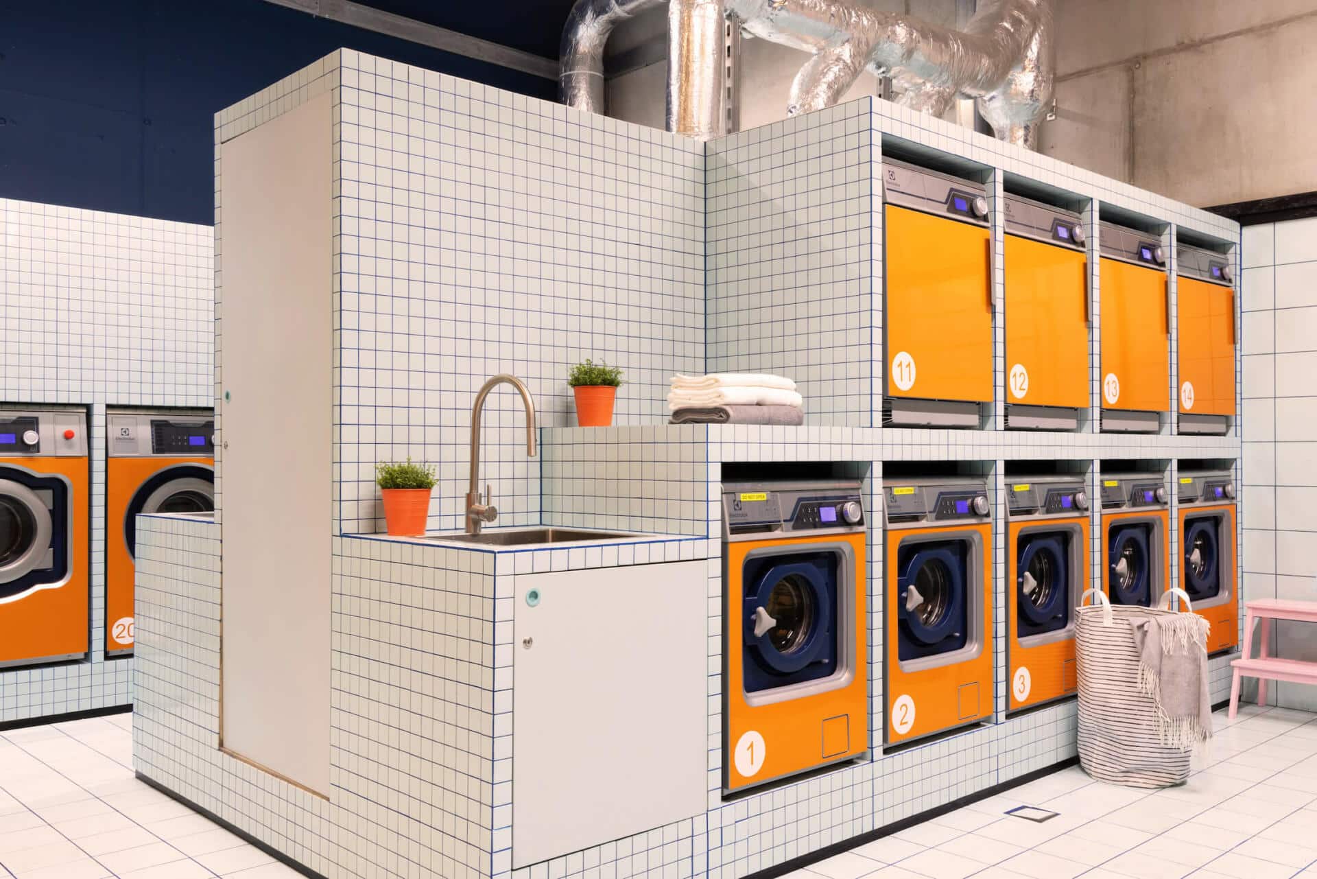 Orange laundry machines and dryers at Basecamp Katowice dorm