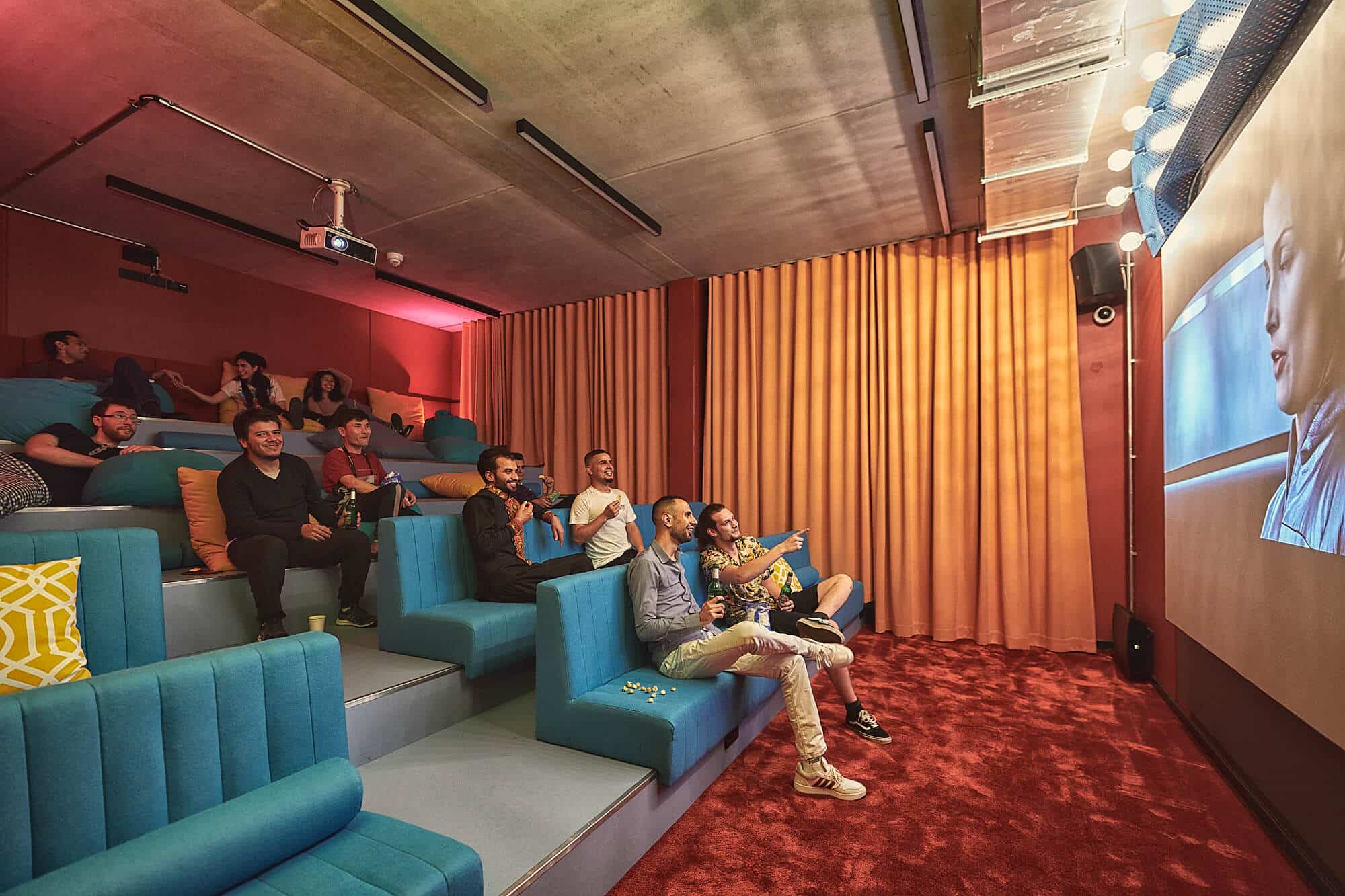 Students watching a movie at Basecamp Gottingen dormitory's cinema room