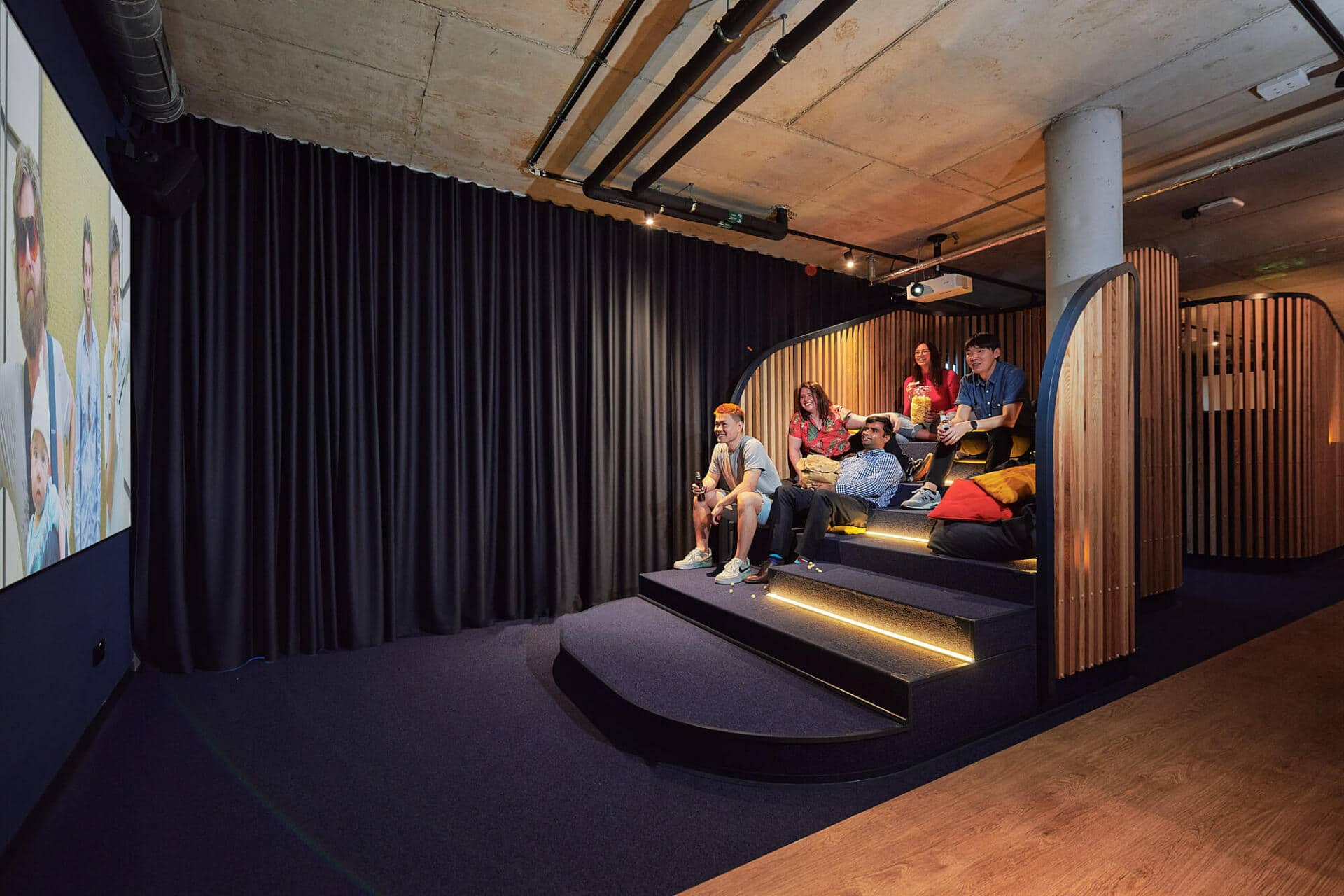 Students watching a movie in the Cinema room at Basecamp Dortmund student accommodation