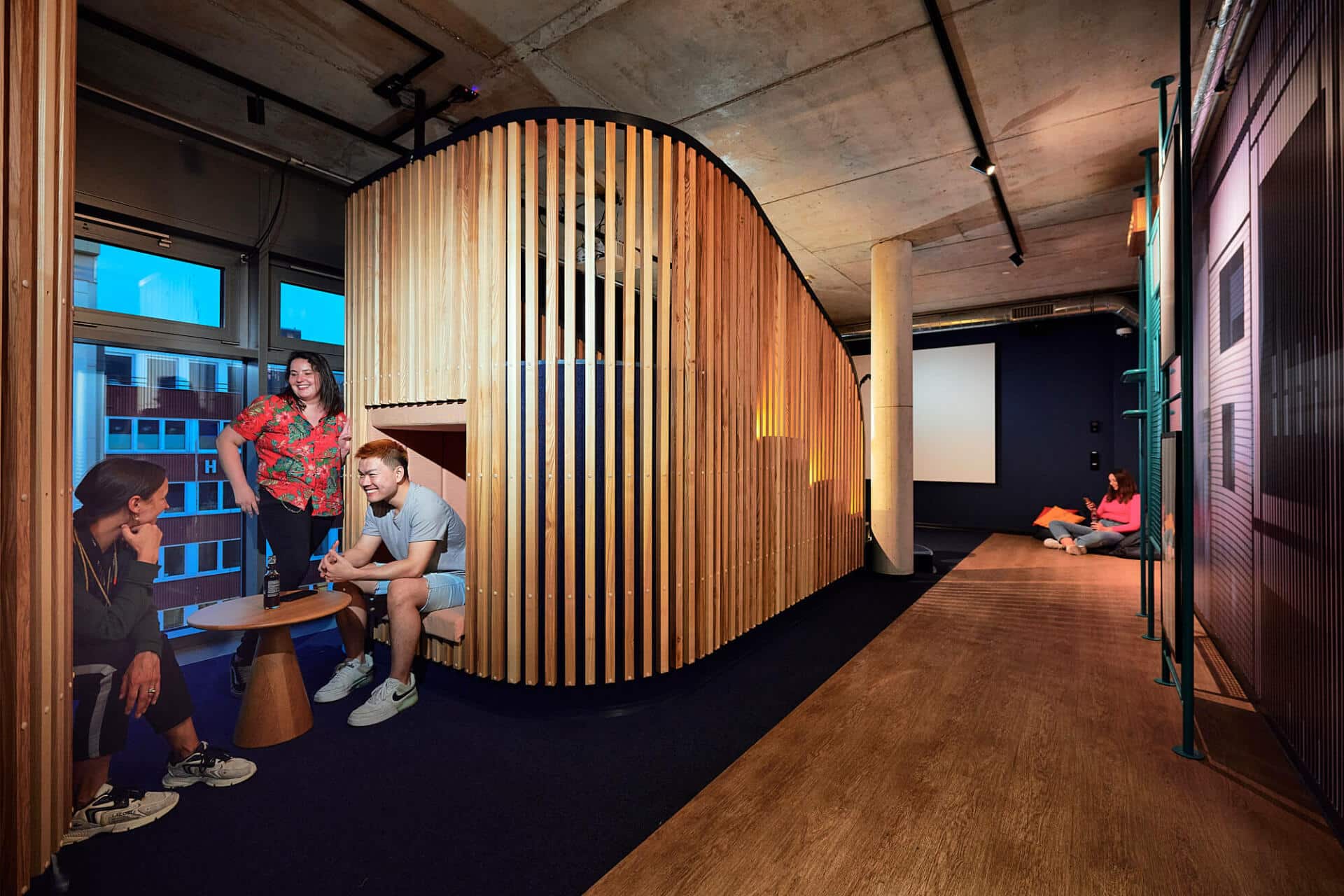 Cinema area with students chatting on the sofas at Basecamp Dortmund dormitory