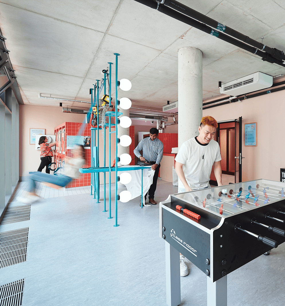 Students iron and wash clothes in the laundry room at Basecam Gottingen student accommodation