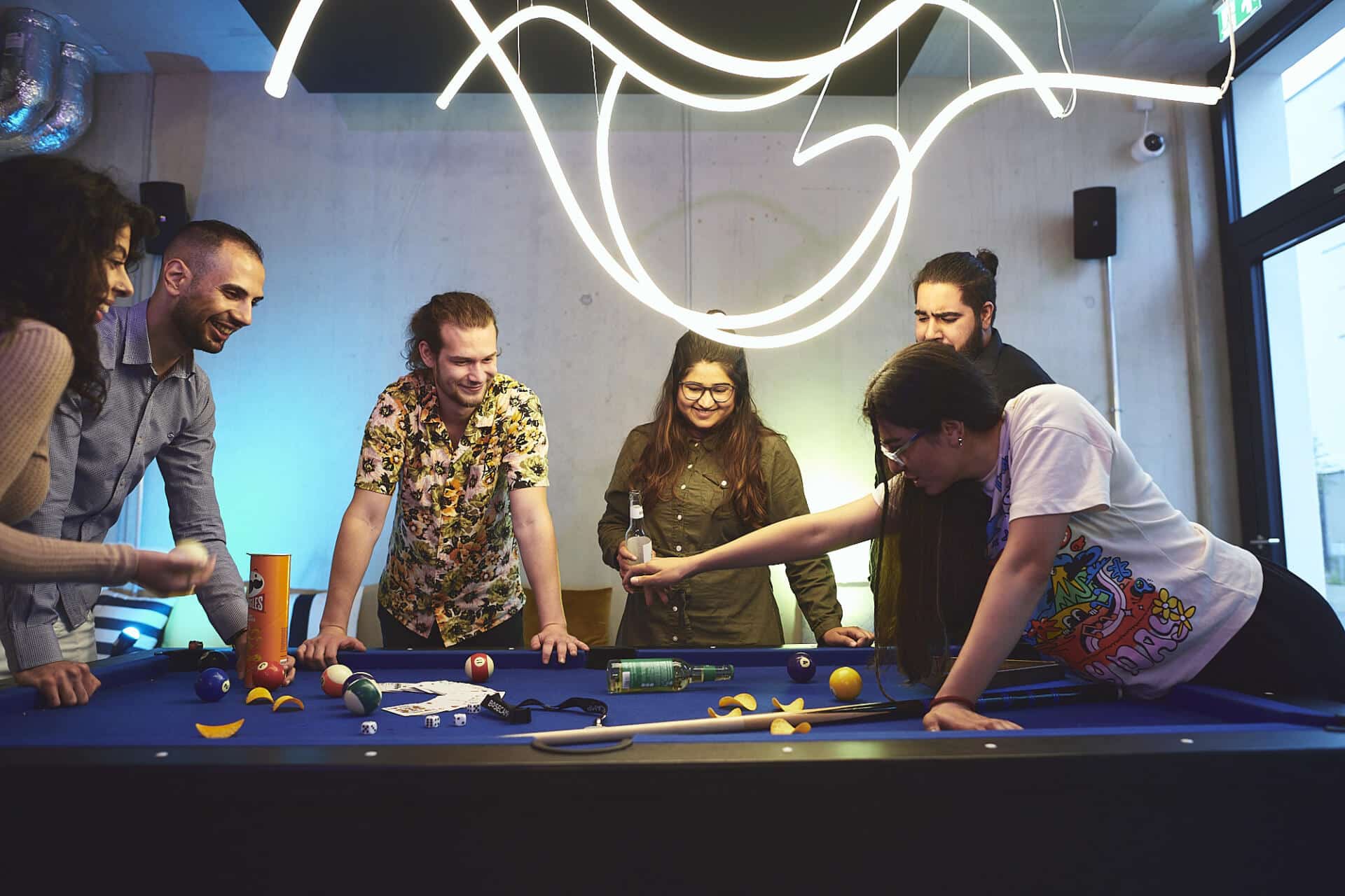 Students play pool and eat in a game zone of Basecamp Gottingen student accommodation