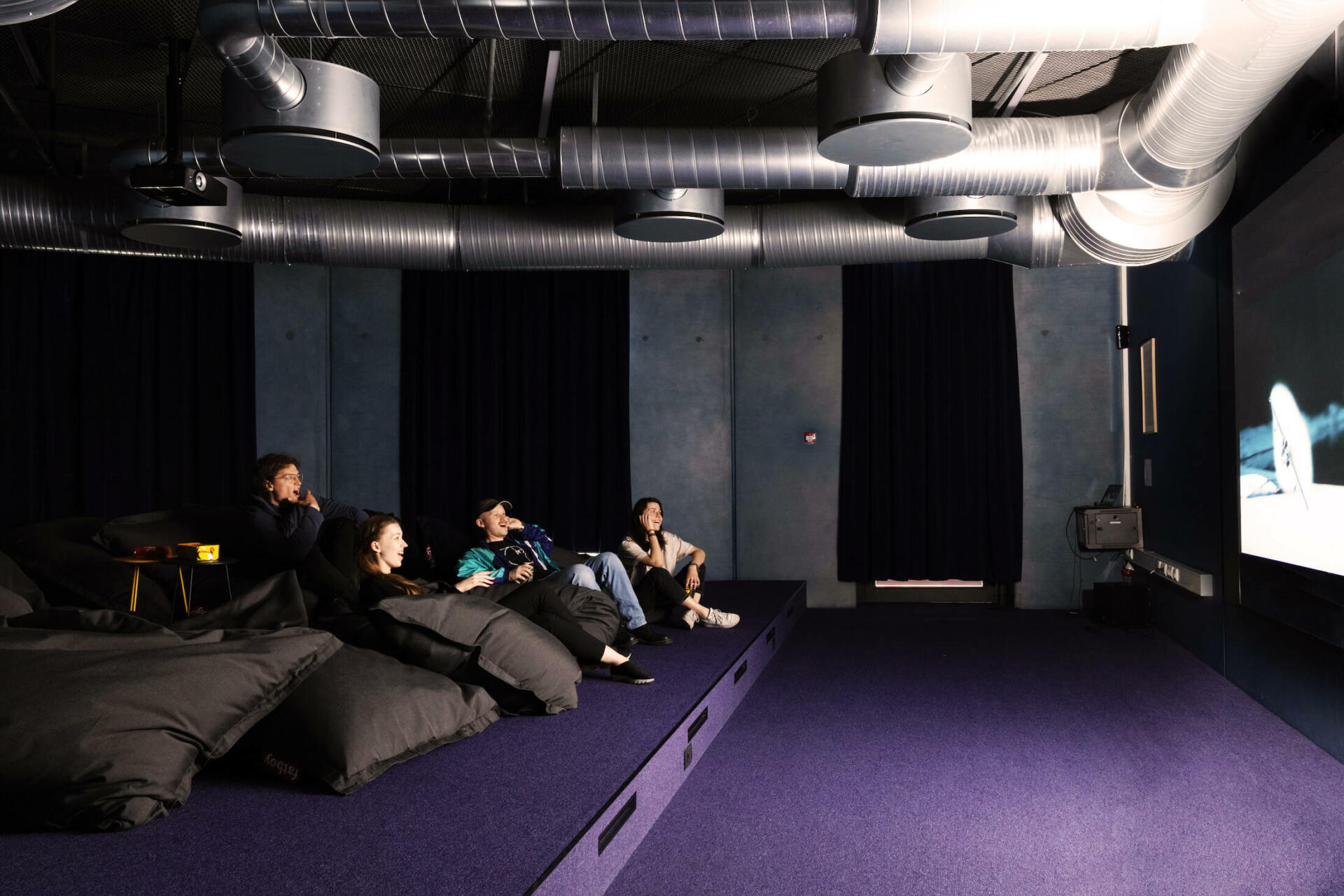 Students laugh in the cinema room of Basecamp Lyngby student accommodation