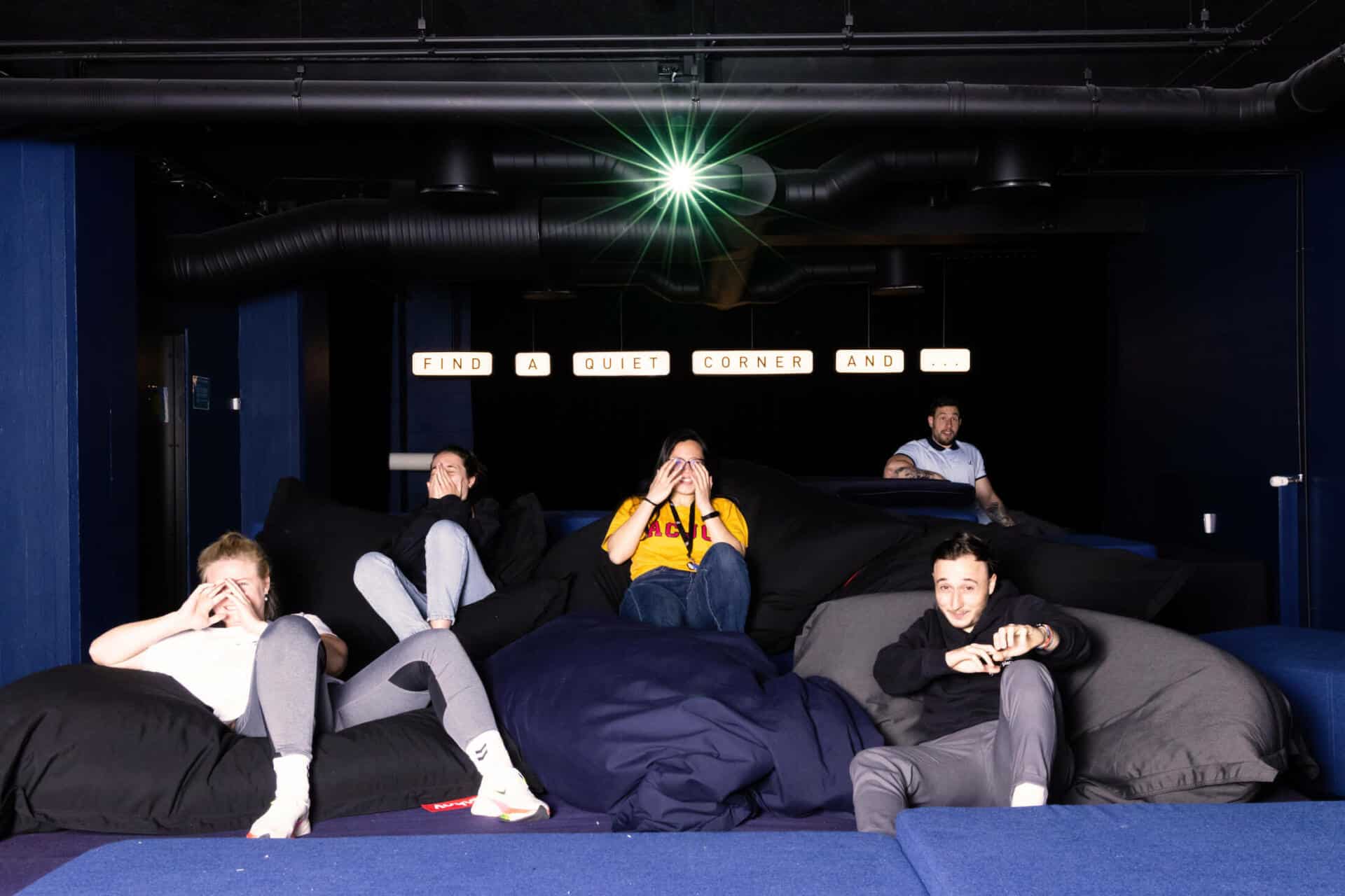 Students covering their eyes while watching a horror movie in the cinema room at Basecamp Copenhagen South Campus dormitory