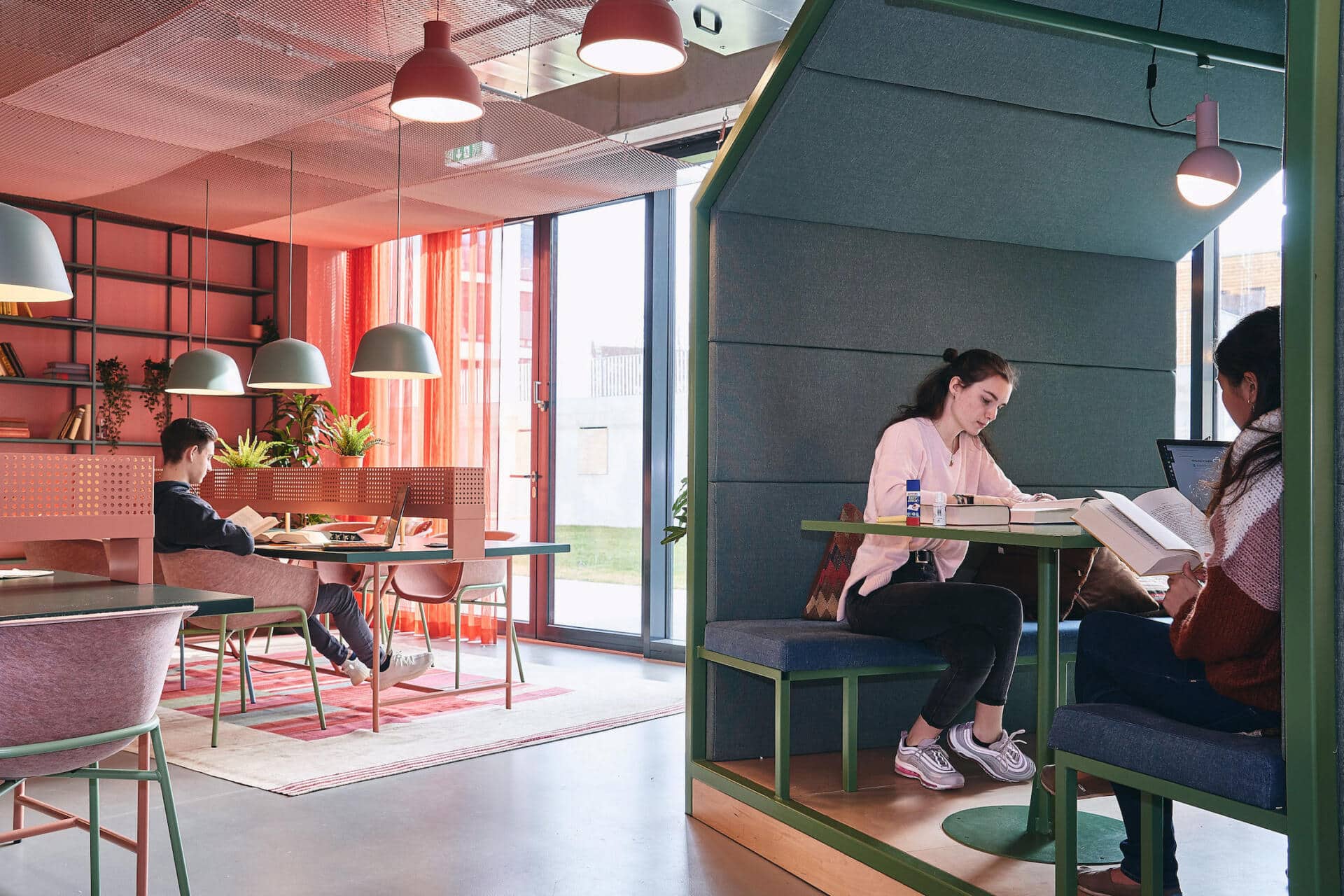 Students read and work in a study space at Basecamp Leipzig student accommodation