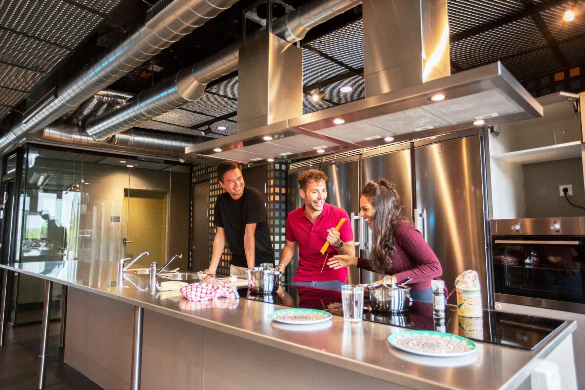 students chat and cook in the common kitchen at Basecamp Lyngby student accommodation