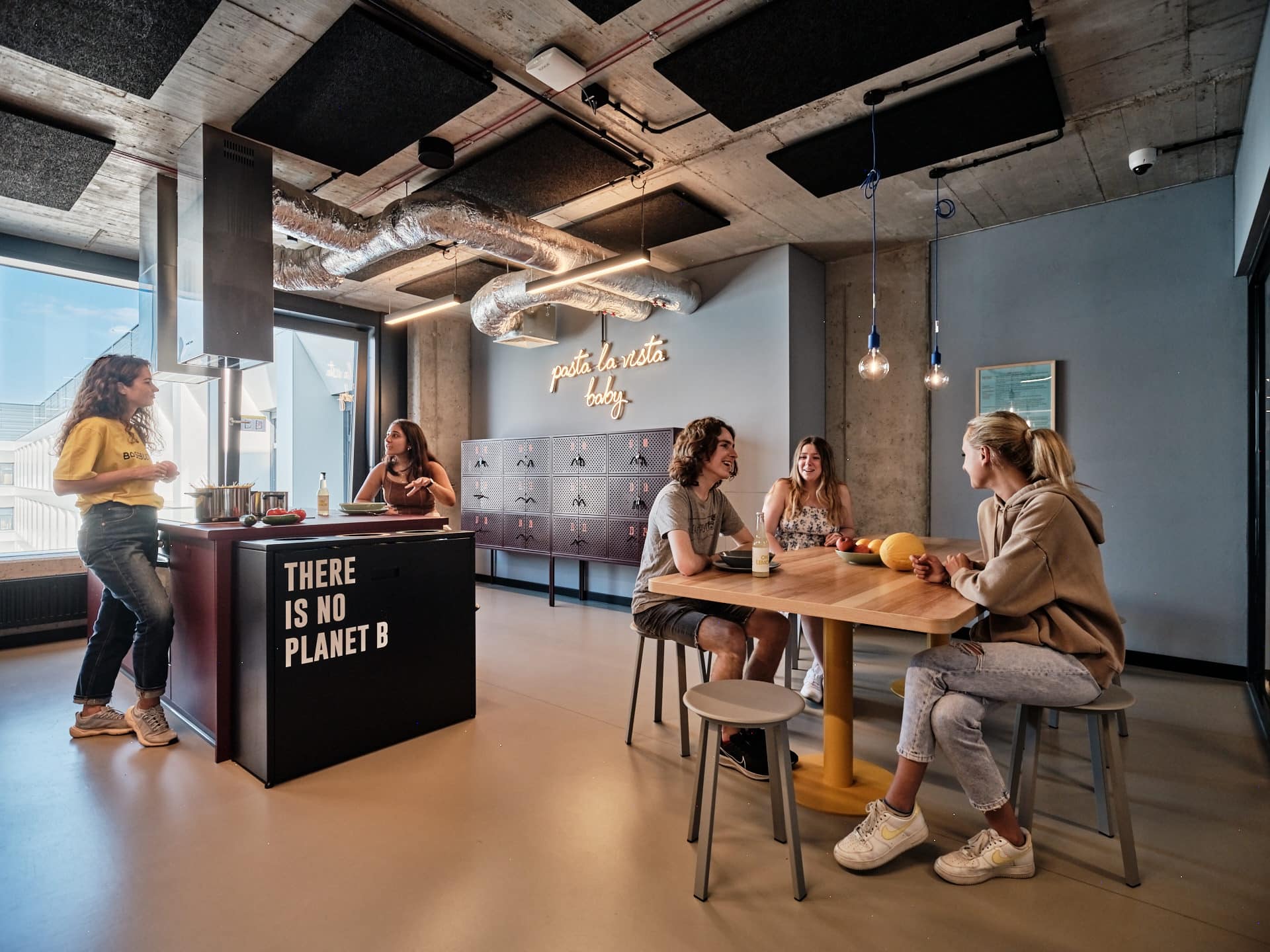 students chat and eat in the common kitchen at Basecamp Wroclaw student dormitory