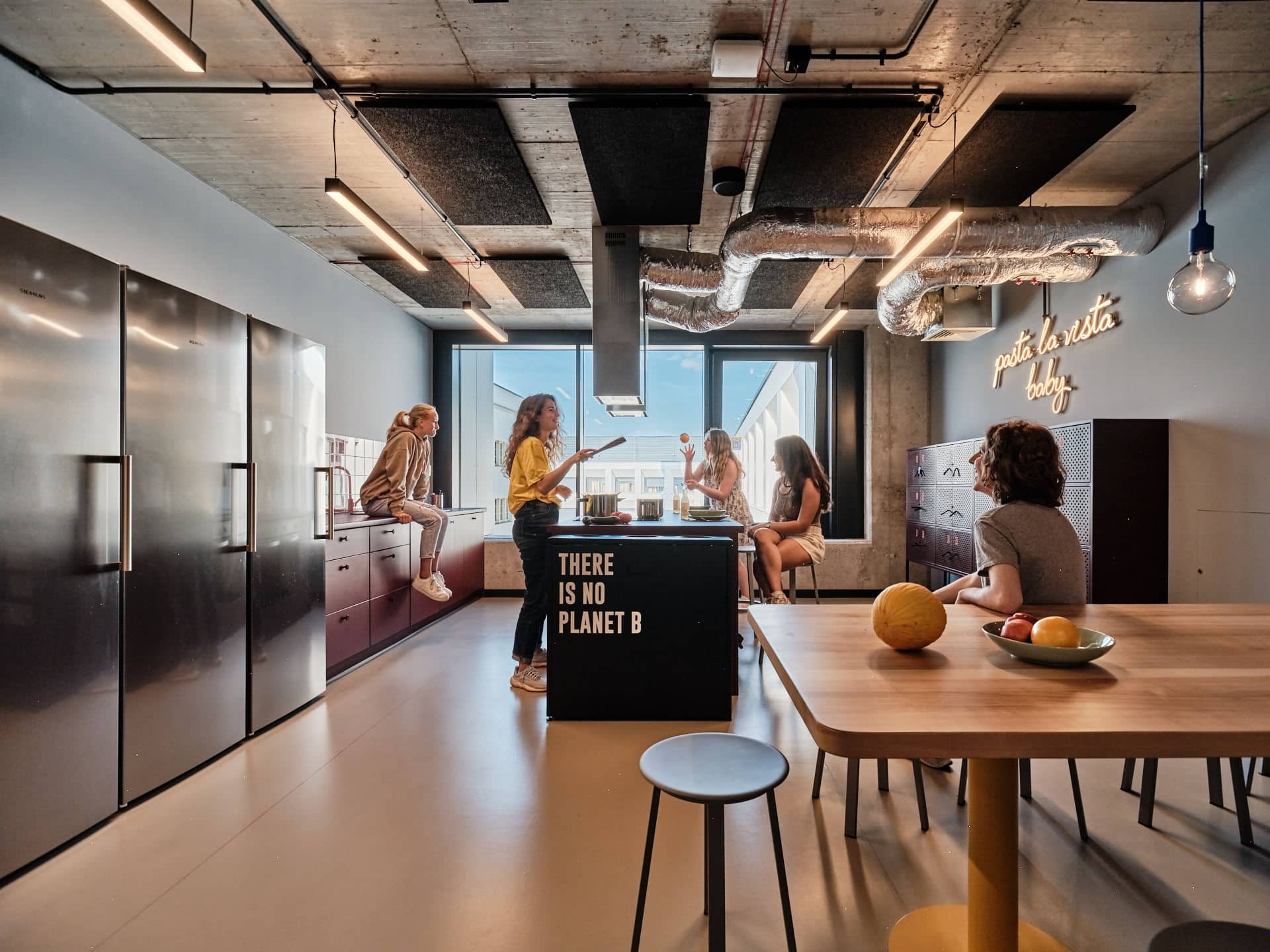 students chat and cook in the common kitchen at Basecamp Wroclaw student dormitory