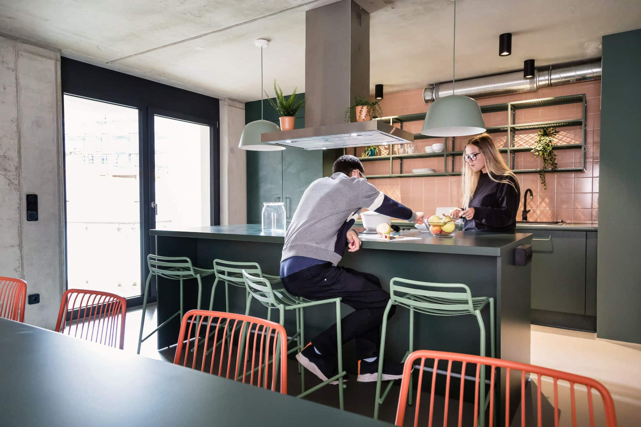 Two students eat and cook at one of the shared kitchens in our student accommodation in Leipzig