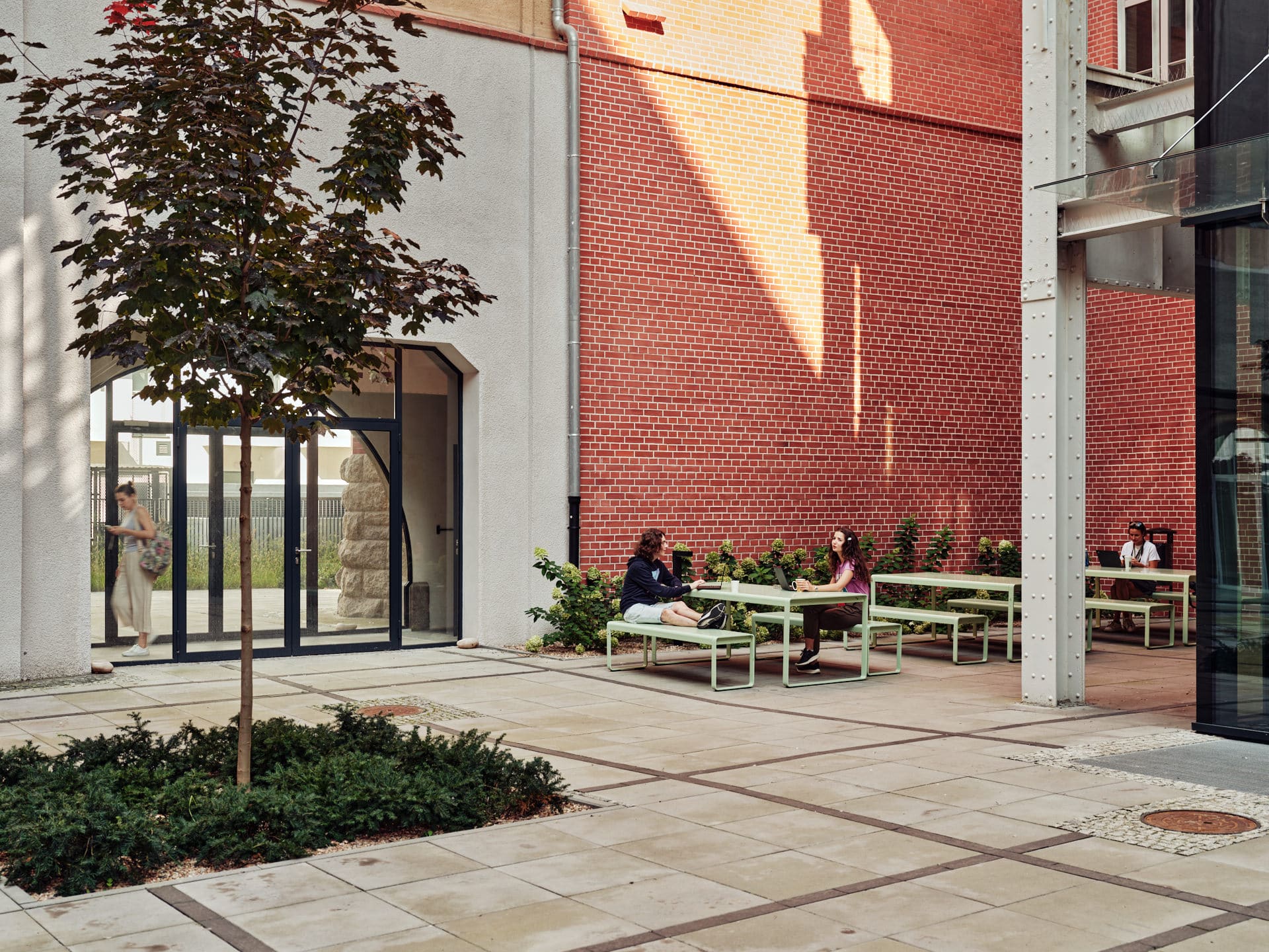 Two students chat in the Outdoor area of Basecamp Wroclaw student dormitory