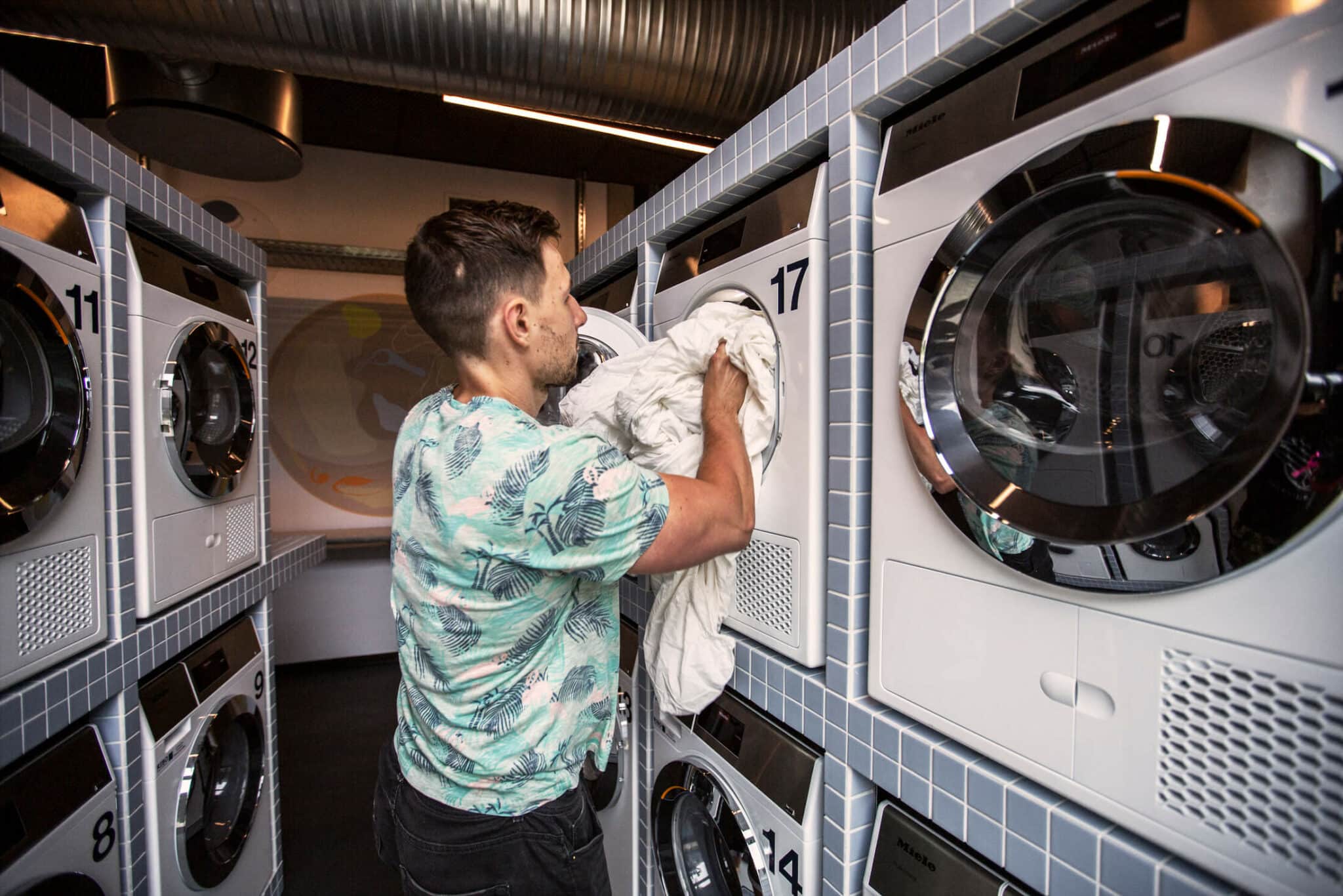 A man uses a laundry machine to wash his sheets at Basecamp Lyngby student apartments